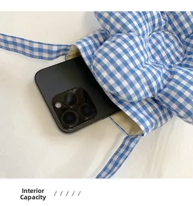 Capacità interna della borsa a fiore a quadretti blu con un grande smartphone inserito