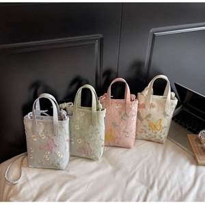 Détail de quatre sacs fourre-tout brodés avec filet en couleurs pastel douces