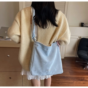 Détail du sac cabas bleu clair à motif nuage avec large bandoulière porté par un mannequin