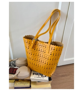 Detail of laser-cut hollow pattern and wavy edge on mustard yellow tote bag