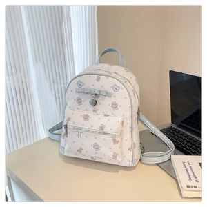 Détail du sac à dos en cuir PU blanc avec motif ours et breloque en forme de cœur argenté