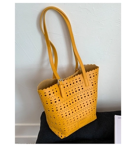 Detail of yellow laser-cut tote bag showing wave edge and adjustable shoulder straps