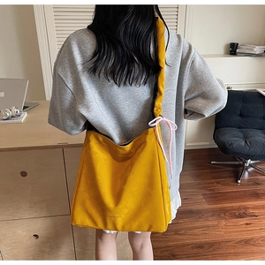 Détail du grand sac cabas jaune avec texture plissée et nœud rose sur la bandoulière