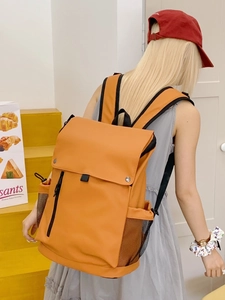 Sac à dos orange en nylon grande capacité avec poches multiples porté par un modèle