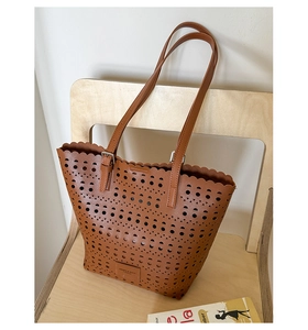 Detail showing the scalloped edge and laser-cut hollow pattern of this brown tote bag