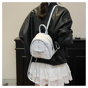 Détail d'un mini sac à dos blanc fleuri avec bretelles bleu clair et nœud décoratif