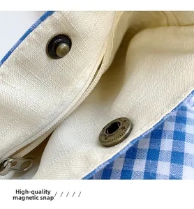 Dettaglio borsa a tracolla a quadretti blu con fibbia magnetica e tasca con zip