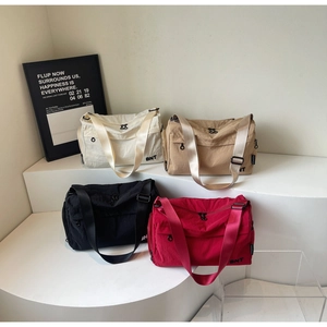Group shot of nylon crossbody bags in white, khaki, black, and red with BNT logo detail