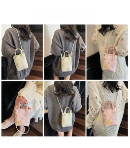 Détail de la broderie florale sur les sacs cabas de style chinois en vert et rose