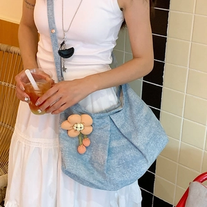Détail du sac à bandoulière en denim bleu clair avec décoration florale orange faite main
