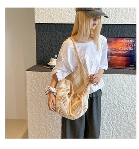 Detail of hand-woven striped crochet shoulder bag showing hollow knit texture and beige tones
