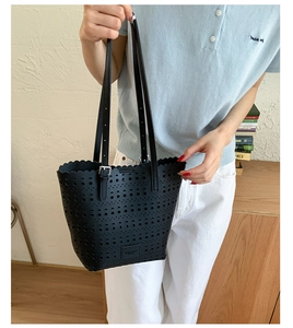 Detail of laser-cut geometric pattern and wavy edges on a black tote bag with straps