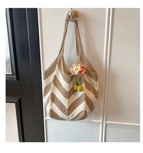 Detail of woven beach tote with V-shape wave pattern and floral crochet charm