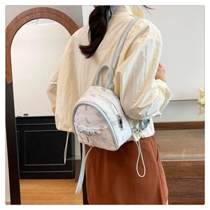 Photo de style d'un mini sac à dos de dessin animé avec nœud et bordure bleu clair