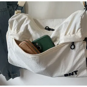 Detailed view of the front zipper pocket with phone and wallet inside a white nylon bag