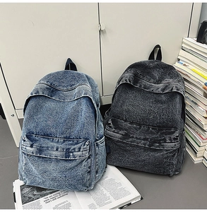 Detailed top view of light blue and dark grey vintage denim backpacks with front pockets