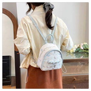 Mini sac à dos blanc avec nœud bleu et motifs de lapin porté par un mannequin