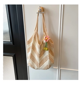 Detailed close-up of woven tote bag with V-shaped texture and handmade floral charm