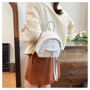 Détail d'un mini sac à dos blanc avec imprimé lapin et bordure bleue sur un mannequin
