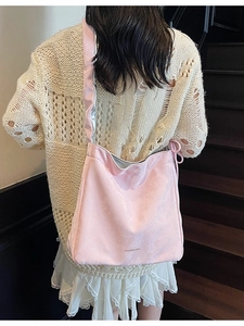 Grand sac cabas plissé en velours rose avec logo porté à l'épaule par un mannequin