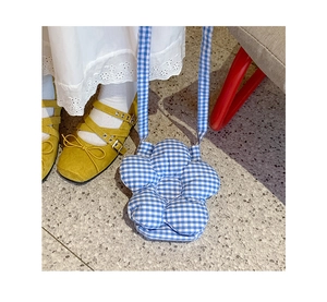 Dettaglio della borsa a tracolla a forma di fiore a quadretti blu e bianchi con tracolla
