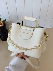 Chic white PU leather bucket bag with gold handle and fashion-forward decorative chain