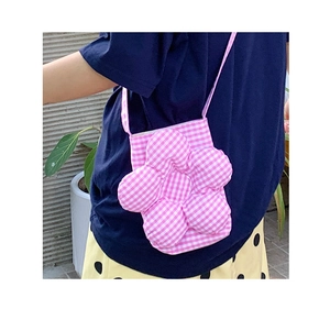 Dettaglio della borsa a fiori a scacchi rosa e bianchi indossata su camicia blu