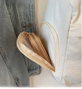 Detail view of nylon bag's layered zipper pocket showing internal storage space