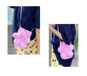 Borsa a tracolla a forma di fiore a quadretti rosa e bianchi indossata da una modella