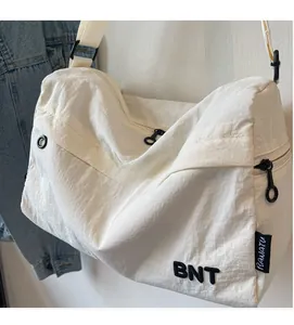 Detail of white nylon crossbody bag with BNT embroidery and textured fabric finish
