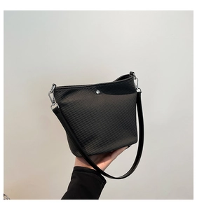 Détails du sac seau noir à texture gaufrée avec garnitures métalliques et bandoulière