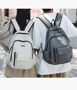 Detail shot of white and grey waterproof nylon backpacks showing large capacity and buckles