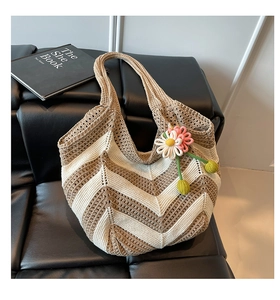 Detail of hand-woven tote bag showing zigzag wave texture and crochet flower charm
