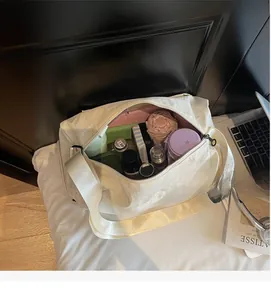 Interior view showing the large capacity of the white nylon crossbody bag with daily items