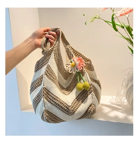 Detail of hand-woven crochet tote bag with wave patterns and floral charm pendant