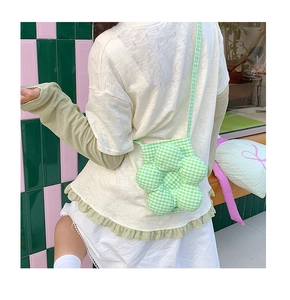 Dettaglio di una borsa a tracolla a forma di fiore con motivi a quadretti verdi e bianchi