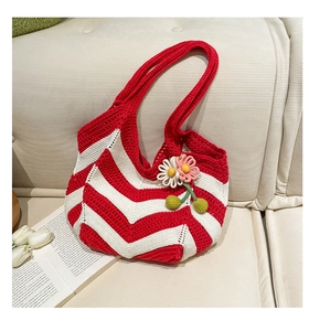 Detail of red and white V-stripe hand-woven bag with decorative crochet flowers on a sofa