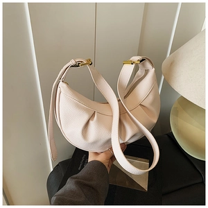 Détail du cuir grainé souple et des plis élégants sur ce sac hobo rose pastel chic
