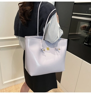 Detail of lavender tote bag featuring knot straps and gold-toned metal tips on the shoulder