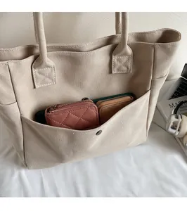 Detailed view of the beige canvas tote bag side pocket with wallets for utility
