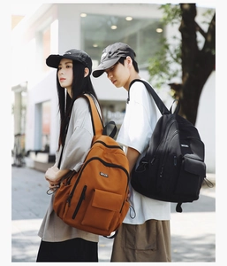 Detail view of large nylon backpacks in orange brown and black for travel and school