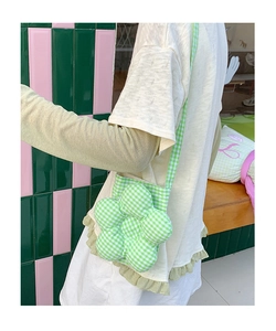 Dettaglio della borsa a tracolla a quadretti bianchi e verdi con design floreale 3D