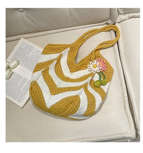 Detail of yellow and white crochet woven tote bag with a handmade floral cherry charm