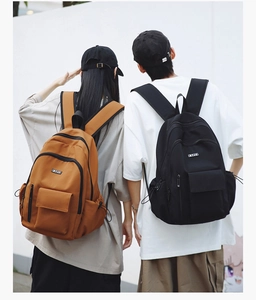 Detailed comparison of brown and black canvas backpacks with front pockets for students