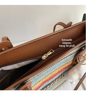 Détail de la fermeture éclair dorée sur un sac cabas tissé coloré avec bordure en cuir