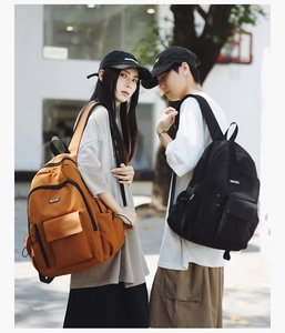 Outdoor street shot of large capacity nylon backpacks in orange and black for students