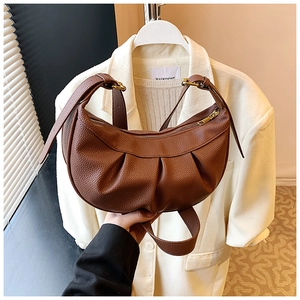 Détail d'un sac croissant en cuir marron à motif litchi avec design plissé élégant