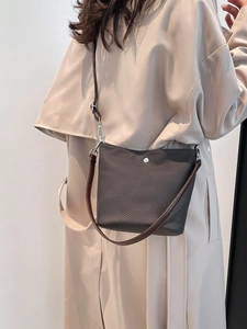 Sac seau texturé marron foncé avec détails argentés pour mode urbaine et quotidienne