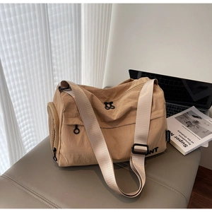 Lightweight nylon shoulder bag with adjustable strap on a bench with a laptop