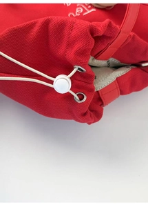 Detail view of the red canvas tote bag showing the drawstring closure and metal eyelets